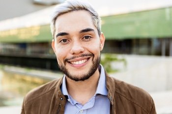 Young hispanic man smiling on camera outdoors - Portrait of happy trendy guy in the city